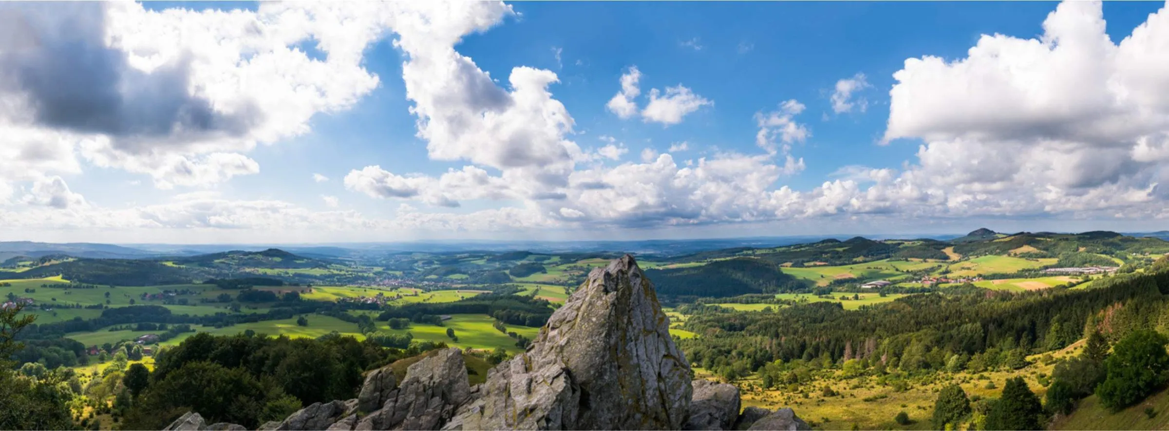 Panoramablick über die Rhön mit Felsen im Vordergrund